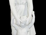 une statue blanche représentant une femme tenant un chien dans ses bras