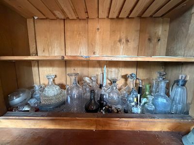une étagère en bois remplie de bouteilles en verre et de flacons