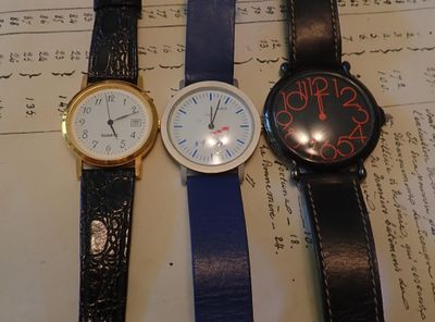 trois montres posées sur un bout de papier sur lequel il y a des inscriptions