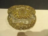une boîte en verre ornée de motifs dorés, posée sur une table