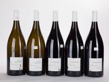 six bottles of wine are lined up in a row on a white surface