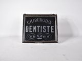 l'enseigne d'un ancien dentiste est affichée sur un fond blanc