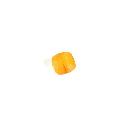 an orange piece of fruit sitting on top of a white surface