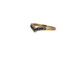 a close up of a gold ring with blue sapphires