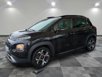 Une Citroën noire est garée sur un sol carrelé à damier