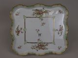 une assiette blanche décorée de fleurs roses et vertes