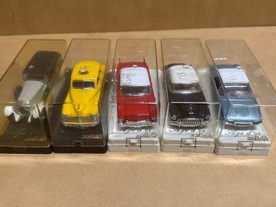 five different models of cars in a display case