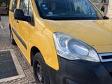the small yellow van is parked on the side of the road