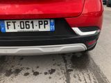 the rear end of a red car parked in a parking lot