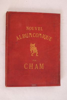 un vieux livre rouge posé sur une table à côté d'un mur blanc