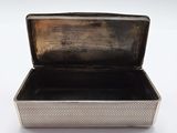 an old silver box sitting on a white surface with its lid open