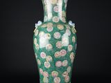 un vase vert orné d'un motif floral