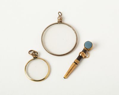 two rings, a magnifying glass and a ring with a blue stone