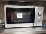 a microwave that is sitting on a shelf in a kitchen