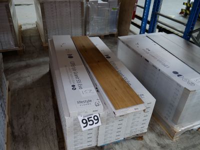 Plusieurs caisses en bois sont empilées sur des palettes dans un entrepôt