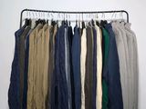 clothes hanging on a rack in front of a white wall