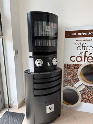 a coffee machine sitting next to a coffee cup dispenser