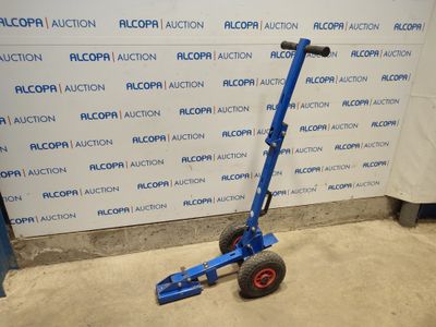 an image of a blue hand truck with wheels in front of a wall