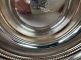 a close up of a silver plate with a clock on it