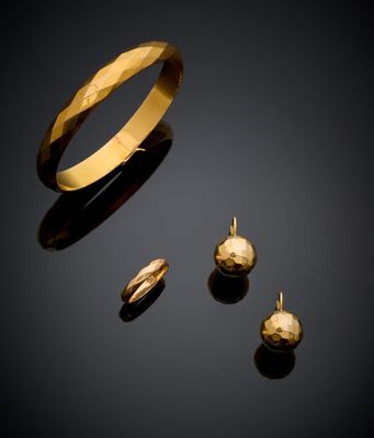 un gros plan d'une bague et d'une boucle d'oreille en or sur une surface noire