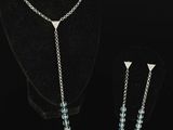 silver plated necklace and earrings with blue crystals on a black mannequin