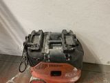 an orange and black machine sitting on the floor next to a white wall