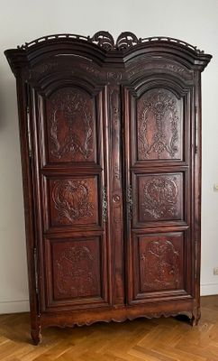 a wooden armoire with carvings on it in a room