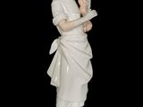 a figurine of a woman holding a bird in her hands