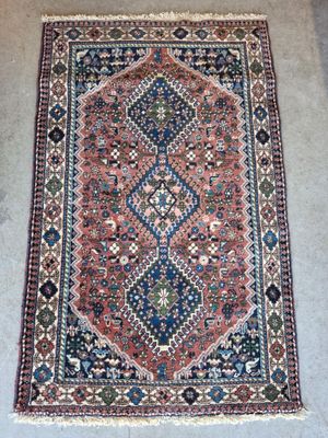 un tapis persan ancien aux motifs bleus, rouges et verts