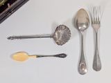 a lot of silver spoons and forks on the table