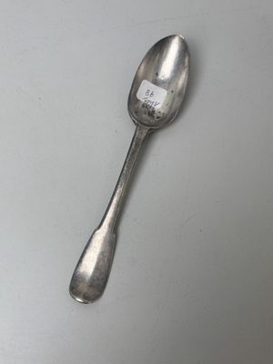 a spoon with a sticker on it sitting on a table