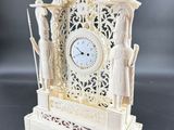 a white clock that is sitting on a table