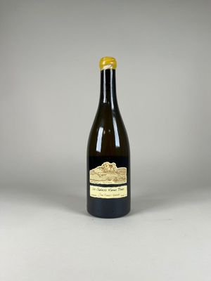 une bouteille de vin posée sur une table blanche
