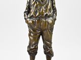 statue en bronze représentant un garçon coiffé d'un chapeau et vêtu d'un pantalon, posée sur un socle en marbre