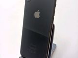 a black iphone sitting on a stand on a white surface