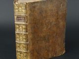 an old book sitting on top of a table with a black background
