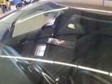 a black car with a sticker on it in a showroom
