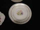 many plates with flowers on them on a table