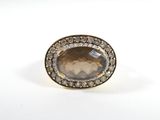 un gros plan d'une bague ornée d'une pierre brune entourée de diamants
