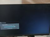 a computer monitor sitting on a desk with a note in front of it