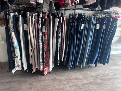 beaucoup de vêtements suspendus à une étagère dans une pièce