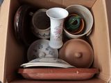 une boîte en carton remplie de différents types de vases et de bols