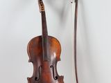 un vieux violon posé sur une table en bois, à côté d'un archet