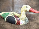 a wooden duck that is sitting on a brown surface