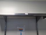 a metal shelf with a sign on it in a room