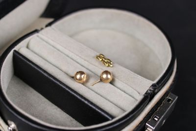 two pairs of earrings in a case on a black surface