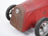 a red toy car that is sitting on a white surface
