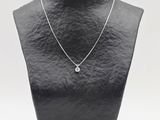 a black mannequin with a silver necklace on a white background