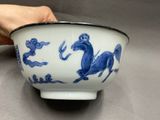 a blue and white bowl with a horse design on it