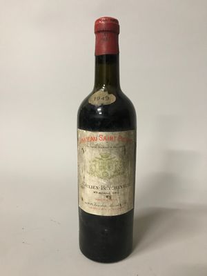 une bouteille de vin rouge posée sur une table blanche